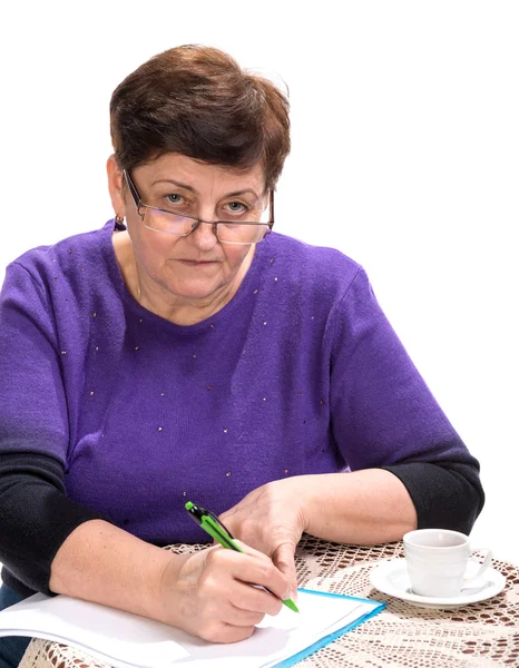 Mujer madura escribiendo documentos con taza de café — Foto de Stock