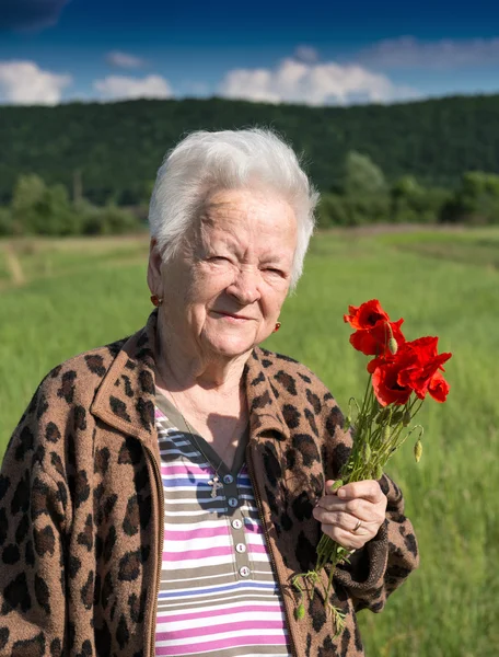 Old woman with poppies — Stock Photo, Image