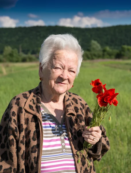 Gamla kvinnan med vallmo — Stockfoto