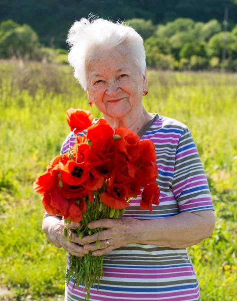 Old woman with poppies — Stock Photo, Image