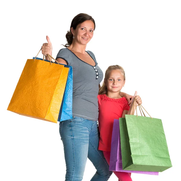 Smiling mother and daughter with shopping bags — Stock Photo, Image