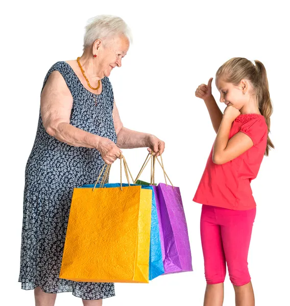 Lachende grootmoeder met kleindochter met shopping tassen — Stockfoto
