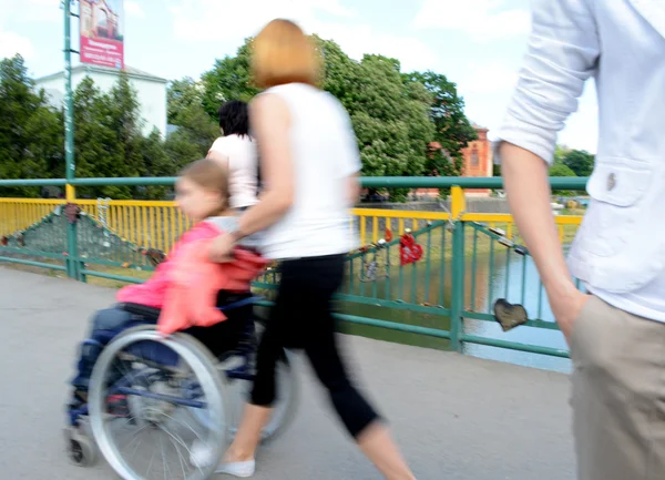 Kind met een handicap in een rolstoel begeleid haar moeder — Stockfoto