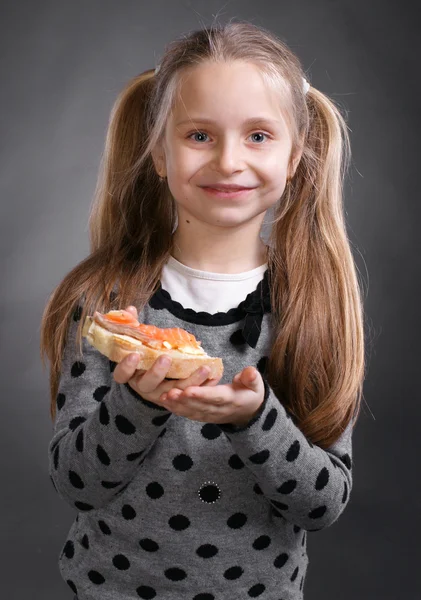 สาวน้อยที่มีความสุข กินขนมปังและเนยกับปลา — ภาพถ่ายสต็อก