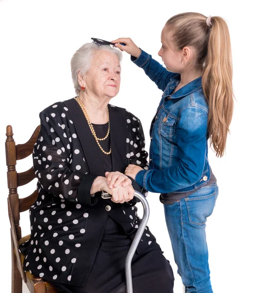 Enkelin kämmt Haare ihrer Großmutter — Stockfoto