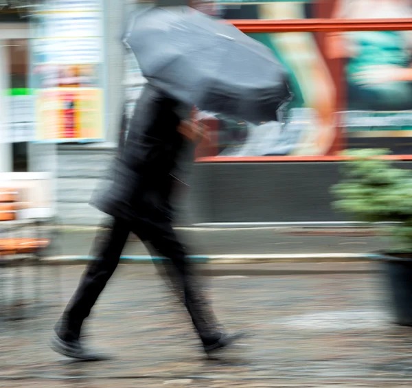 Mann läuft an regnerischem Tag die Straße entlang — Stockfoto