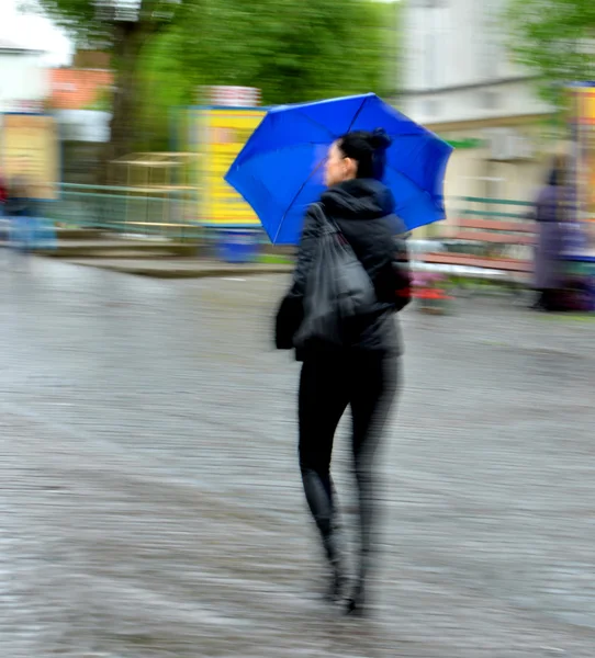 Femme marchant dans la rue un jour de pluie — Photo