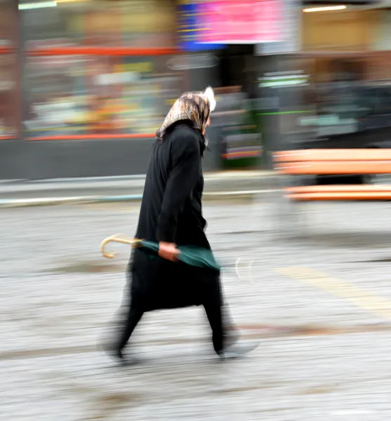 Woman walking in the street on a rainy day — Stock Photo, Image