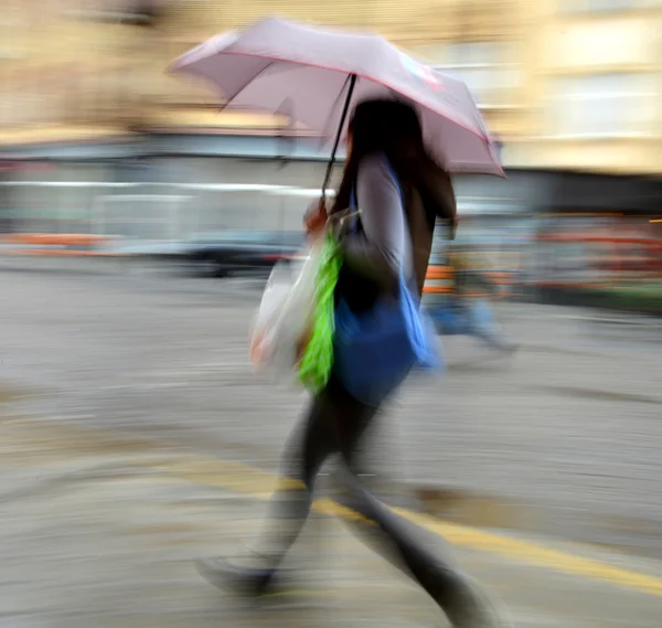 Γυναίκα που περπατά στο δρόμο για μια βροχερή ημέρα — Φωτογραφία Αρχείου