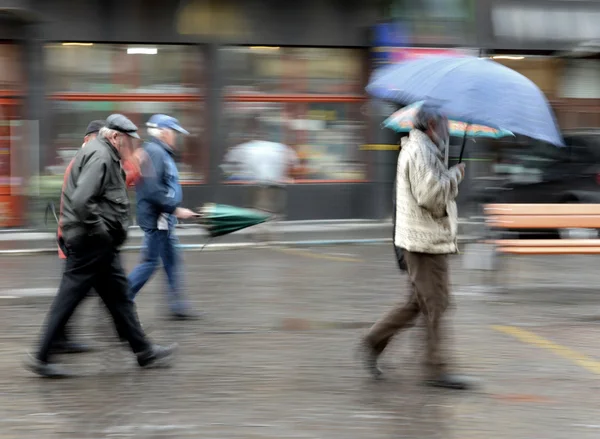 Mensen lopen in de straat op regenachtige dag — Stockfoto