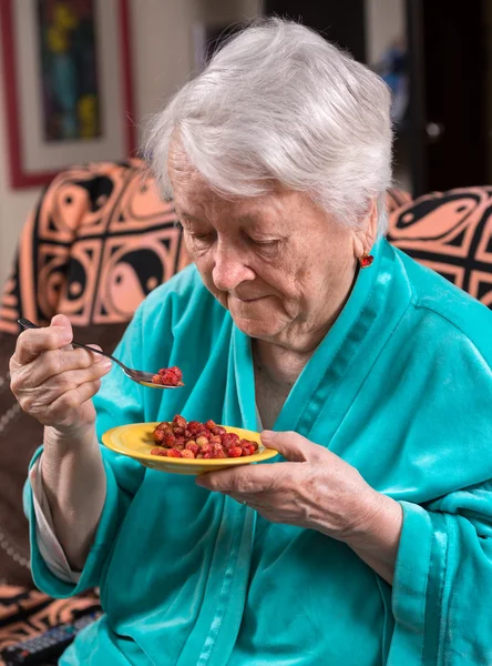 Mulher velha comendo morango — Fotografia de Stock