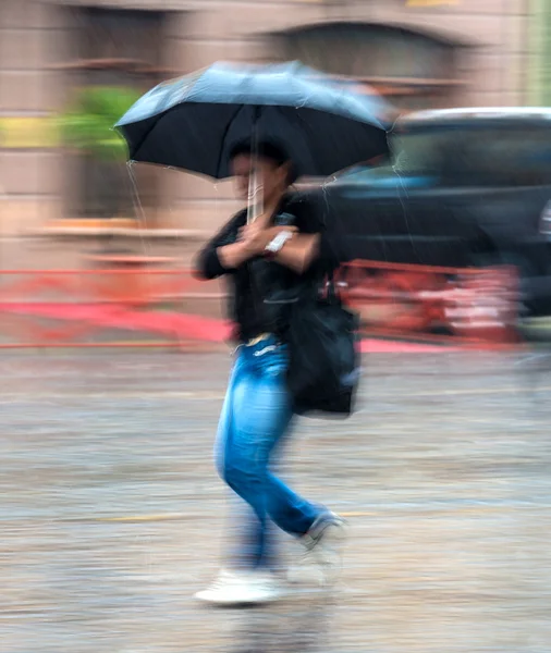 Mulher andando pela rua em um dia chuvoso — Fotografia de Stock