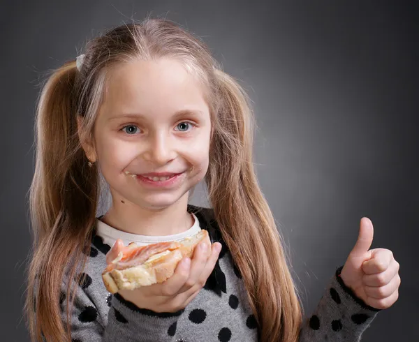 Menina feliz comendo pão e manteiga com peixe — Fotografia de Stock