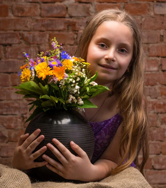 Beautiful girl in studio with flowers — Stock Photo, Image