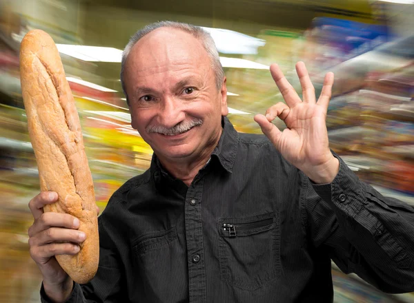 Happy senior man holding fresh baguette — Stock Photo, Image