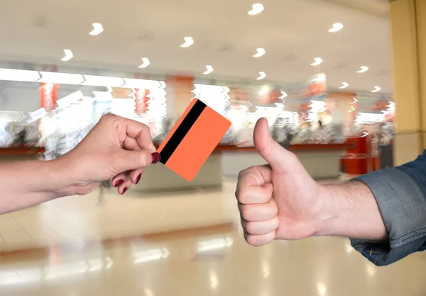 Woman holding credit card, man gesturing thumb up — Stock Photo, Image