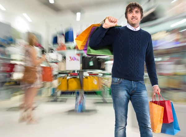 Glimlachende man met shopping tassen — Stockfoto