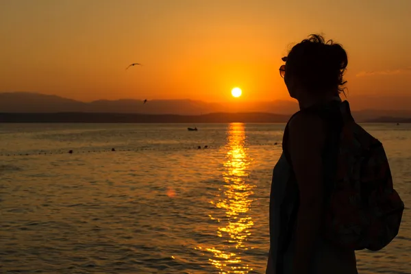 Jovem mulher desfrutando do pôr do sol — Fotografia de Stock