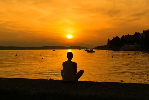 Femme profitant du coucher de soleil sur la plage — Photo