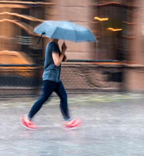 Vrouw op een regenachtige dag onderaan de straat loopt — Stockfoto