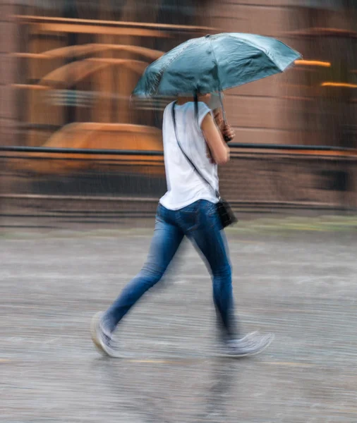 Vrouw op een regenachtige dag onderaan de straat loopt — Stockfoto