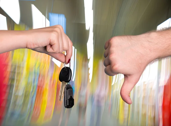 Woman holding car key, man showing thumb down — Stock Photo, Image