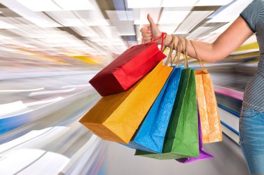 kadın alışveriş torbaları holding ve başparmak yukarıya el hareketi