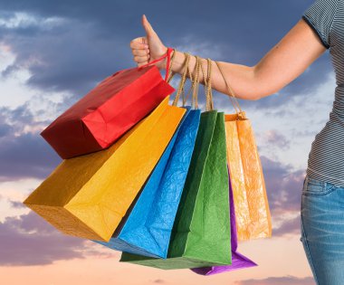kadın alışveriş torbaları holding ve başparmak yukarıya el hareketi 