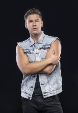 Stüdyoda siyah arka planda poz veren ciddi yakışıklı bir adamın portresi.