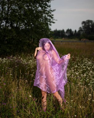 Gün batımında dışarıda poz veren çıplak bir kadının romantik görüntüsü. Seksi çıplak esmer. 