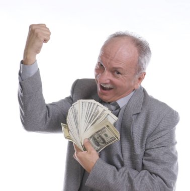 Mutlu gülümseyen kıdemli işadamı bir deste doları elinde tutuyor. Beyaz arka planda stüdyoda poz vermek