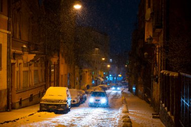 UZHOROD, UKRAINE - 16 Ocak 2021: Uzhhorod, Ukrayna 'da gece karla kaplı şehir manzarası. Dukhnovycha şehrin merkezi sokağıdır.