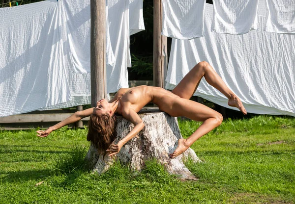 Yatak çarşafları kurutma karşı poz güzel genç çıplak kadın. Yaz zevk