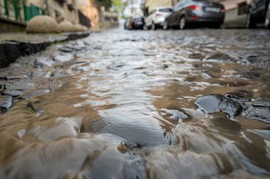 Uzhhorod, Ukrayna - 24 Nisan 2022: Uzhhorod, Ukrayna 'da şiddetli yağmur. Dukhnovich caddesinde su akıntısı var.