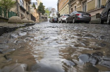 Uzhhorod, Ukrayna - 24 Nisan 2022: Uzhhorod, Ukrayna 'da şiddetli yağmur. Dukhnovich caddesinde su akıntısı var.