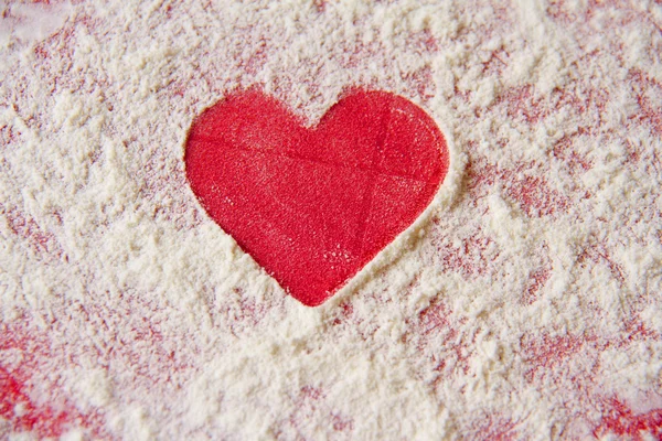 Découpe simple en forme de coeur rouge dans la farine — Photo