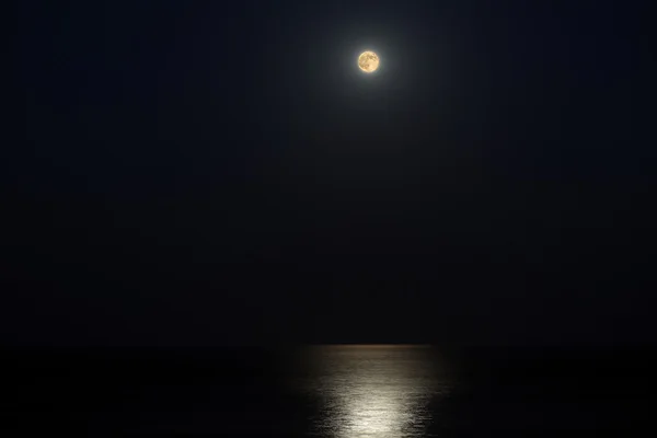 Moonlit path on the smooth sea water Stock Image