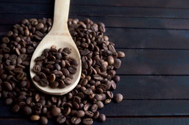 Kahve çekirdeklerinin üzerinde kahve çekirdekleri olan tahta kaşık..
