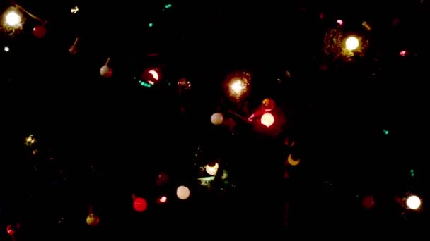 La guirnalda en el árbol de Navidad juega con las luces por la noche — Vídeo de stock