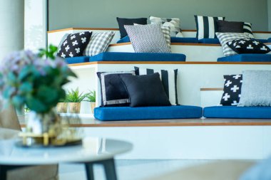 Çalışma alanındaki ahşap basamaklarda ön planda bulanık yastıklar var.