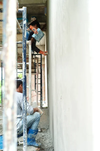Zadní Pohled Pracovníky Omítající Beton Povrchu Zdi Staveništi — Stock fotografie