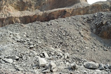 Arka planda bulanık dağ ile birlikte açık hava madeninde ezilmiş taş yığını.