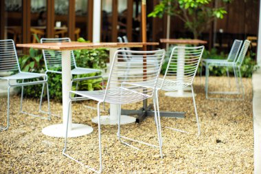 Modern metal koltuklardan oluşan yakın çekim grubu ve açık kafede beyaz renkli masa.