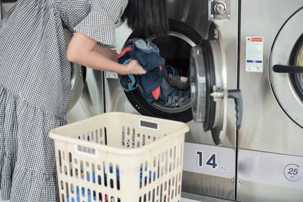 선택적으로 기계에 더미에 초점을 맞추고 여자가 빨래를 세탁기에 스톡 사진