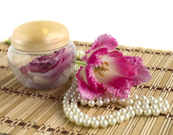 Perlenkette und Blütenblätter im Glas — Stockfoto
