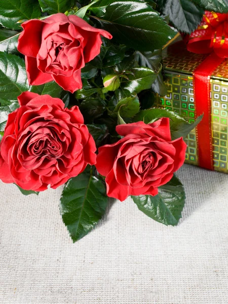 Three red roses and gift — Stock Photo, Image