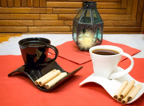 two cups of coffee and wafer sticks with chocolate