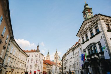 Ljubljana Şehir Meydanı güneşli bir günde, Slovenya 'nın başkenti. Ljubljana Belediye Binası, Robba Çeşmesi ve Ljubljana Katedrali 'ni görebiliriz.