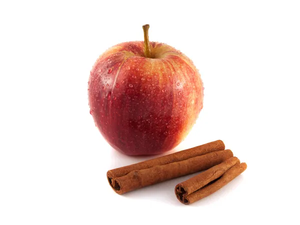 Isolated wet red apple with cinnamon pods — Stock Photo, Image