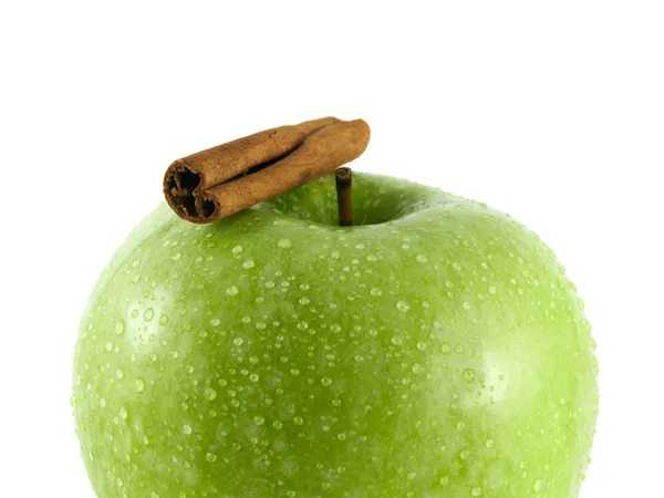 Geïsoleerde groene appel met kaneel peul op wit — Stockfoto